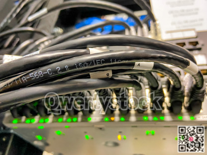 Ethernet cables connected to network equipment with green lights in data center
