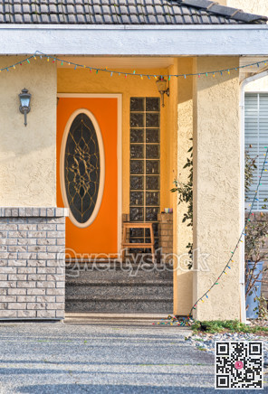 Orange entrance door of residential house on bright sunny day