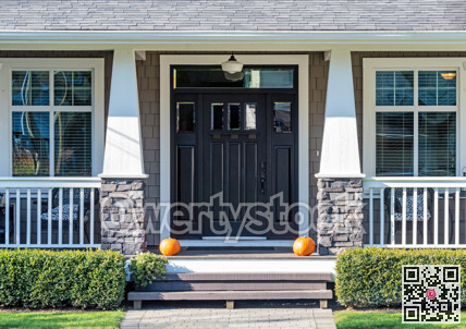 Decorative ripe pumpkins laying in front the house entrance