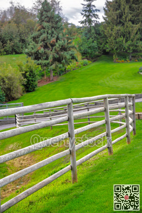 Wood log fence on green fields background