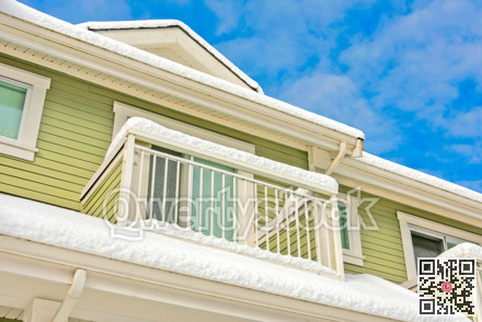 Top of residential building with patio and roof covered with snow