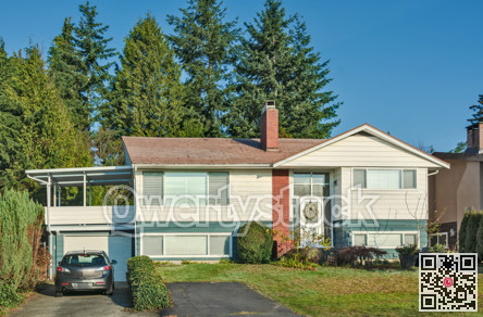 Inexpensive residential house with grey car parked on the driveway.