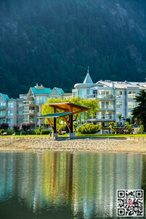 Resort buildings at waterfront on mounting forest background