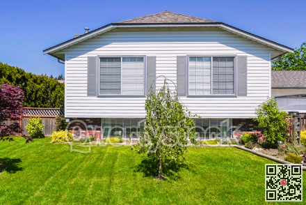 Front yard and facade of family house on blue sky background