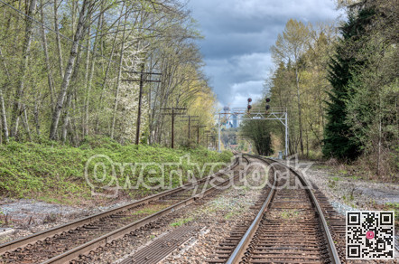 Curve of rail road pathways leading to a city