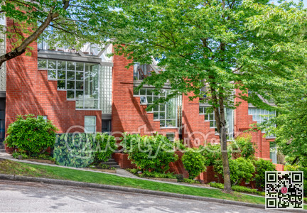 Residential townhouses among the trees on the street going downhill
