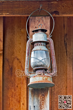 Old rusty oil-lamp under summer wooden shed