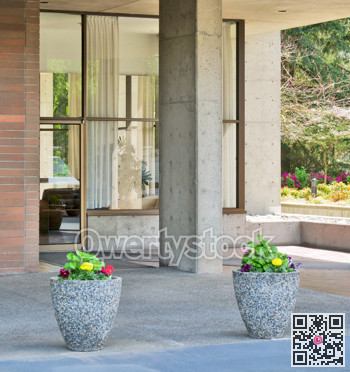 Two small flower beds in front of residential building entrace