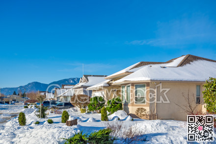Street of residential houses in snow on winter sunny day