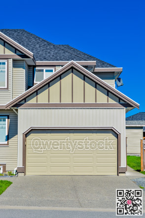 Double wide garage door of residential house with concrete driveway in front