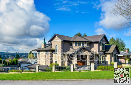 Big residential house on bluesky background with metal fence in front