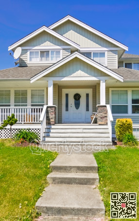 Entrance of family house with concrete pathway over green lawn in front
