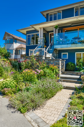 Family house with weedy front yard on blue sky background