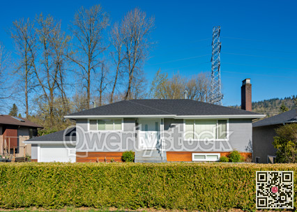 Family house with green fence on the front yard and power line on the back