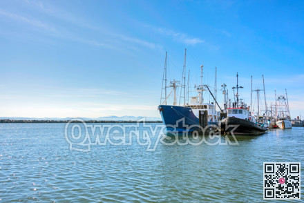 Small fishing trawler and tugboat moored at the ocean pier