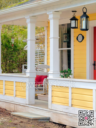 White chair with red pillow on the porch of historical residential house