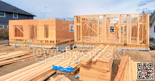 Wooden frame of two new houses with engineered lumber materials in front