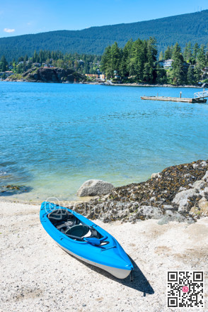 Blue lightweight canoe boat on a shore of Pacific ocean bay on sunny day