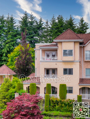 Italian style low-rise residential building with decorative trees in front